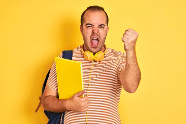 学生们带着背包耳机 在孤立的黄色背景下拿着笔记本 怒气冲冲地大叫 疯狂地高喊 怒气冲冲 — 图库照片