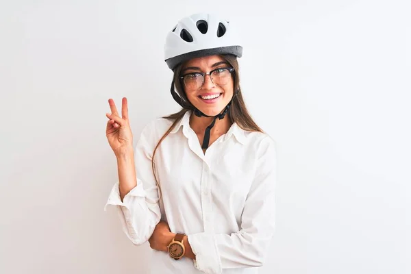 漂亮的女商人戴着眼镜 戴着自行车头盔 站在孤独的白色背景上 高兴地微笑着 脸上闪烁着胜利的标志 第二点 — 图库照片