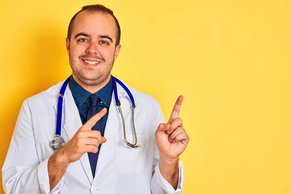 Joven Doctor Vistiendo Abrigo Estetoscopio Parado Sobre Fondo Amarillo Aislado —  Fotos de Stock