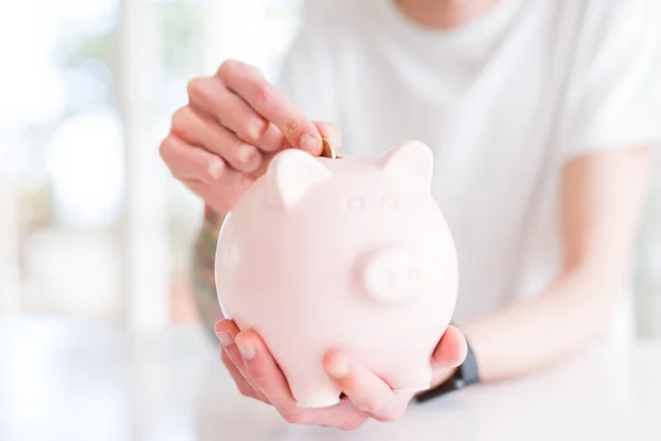 Close-up van de mens zetten van een munt binnen Piggy Bank als besparingen — Stockfoto