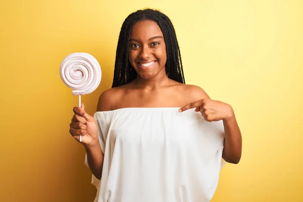 Young African American Woman Eating Candy Standing Isolated Yellow Background — Stock Photo, Image