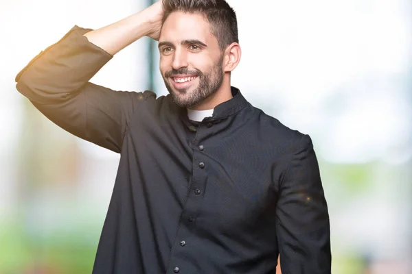 Young Christian priest over isolated background Smiling confident touching hair with hand up gesture, posing attractive