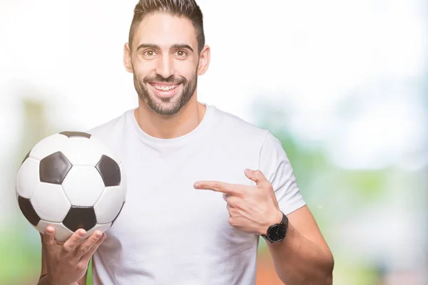 若い男の手と指で指している非常に満足の孤立した背景にサッカー サッカー ボールを保持しています — ストック写真