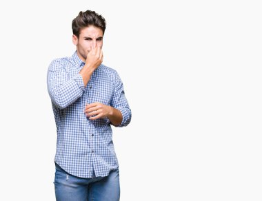 Genç yakışıklı iş adamı izole arka plan bir şey pis ve iğrenç kokulu, dayanılmaz koku, holding nefes burun parmaklar ile. Kötü kokuyor kavramı.