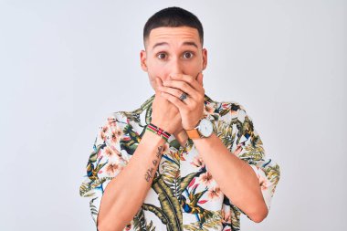 Tecrit edilmiş arka planda Hawaii tişörtü giyen genç yakışıklı adam yanlışlıkla ağızlarını kapatarak şok geçirdi. Gizli konsept.