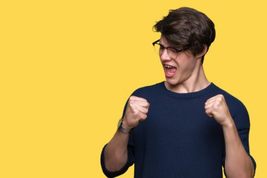 Gülümseyen ve başarı için çığlık izole arka plan çok mutlu ve heyecanlı kaldırdı, silah ile kazanan jest yapıyor üzerinde gözlük takan yakışıklı delikanlı. Kutlama kavramı.