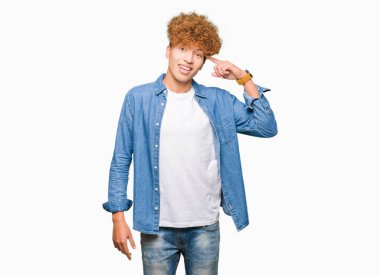 Genç yakışıklı adam ile afro saç giyen denim ceket bir parmak ile kafa işaret gülümseyen, harika bir fikir veya düşünce, iyi bellek