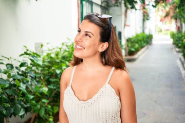 Puerto de Mogan 'ın renkli köyünde genç ve güzel bir kadın. Yaz tatilinde sokakta mutlu bir şekilde gülümsüyor.