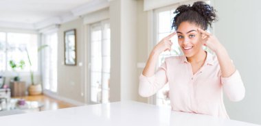 Afro saçlı, iki eliyle başını gösteren güzel Afro-Amerikan kadını geniş açılı. Harika fikir ya da düşünce, iyi hafıza.