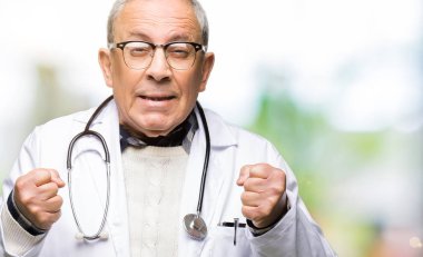 Yakışıklı kıdemli Doktor adam silah ile başarı için heyecan gülümseyen zafer kutluyor kaldırdı tıbbi ceket giyiyor. Kazanan kavramı.