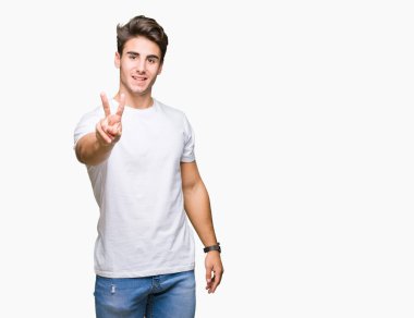 Yakışıklı delikanlı gösterilen ve parmakları ile işaret izole arka plan üzerinde beyaz t-shirt giyen ikincisi ise kendinden emin ve mutlu gülümseyerek.