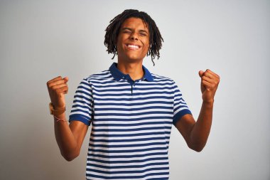 Sarı çizgili mavi polo giyen Afro bir adam izole edilmiş beyaz arka planda durup kolları havada ve gözleri kapalı bir şekilde başarının şaşkınlığını ve şaşkınlığını kutluyor. Kazanan konsept.