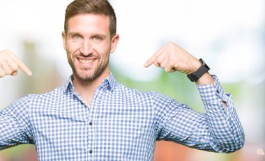 Yüzünde gülümseme ile kendinden emin görünüyorsun, kendini gururlu ve mutlu parmakları ile işaret mavi gözlü yakışıklı iş adamı.