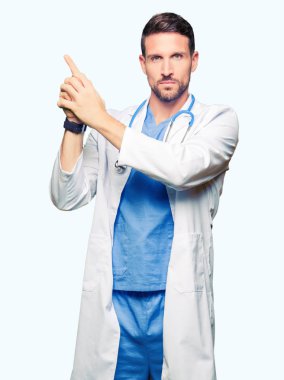 El hareketi ile sembolik silah tutan, çekim silah, kızgın yüz öldürme oynarken arka plan üzerinde tıbbi üniforma giyen yakışıklı Doktor adam izole
