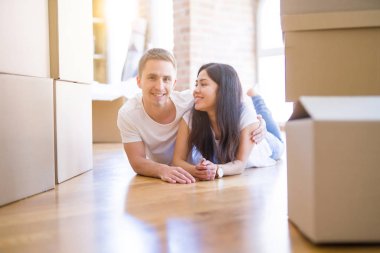 Genç güzel çift karton kutular etrafında yeni evde yatarken