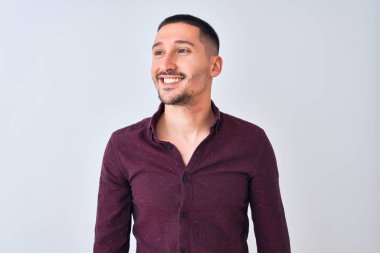 Young handsome business man standing over isolated background looking away to side with smile on face, natural expression. Laughing confident.