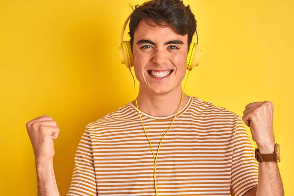 Teenager Chlapec Nosí Sluchátka Přes Izolované Žluté Pozadí Oslavující Překvapen — Stock fotografie