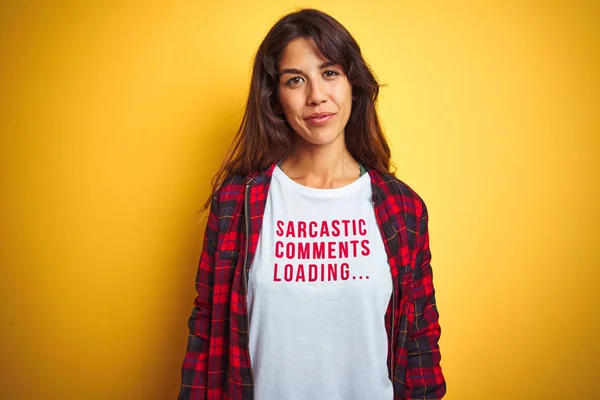 Beautiful woman wearing funny t-shirt with irony comments over isolated yellow background with a confident expression on smart face thinking serious