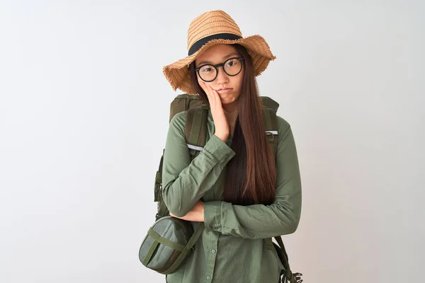 Chinese hiker woman wearing canteen hat glasses backpack over isolated white background thinking looking tired and bored with depression problems with crossed arms.