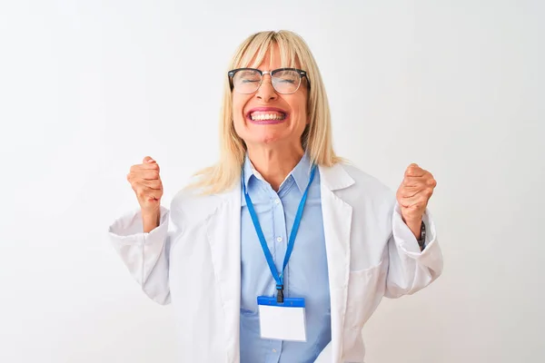 中世の科学者の女性は 孤立した白い背景の上に眼鏡とIdカードを身に着けている非常に幸せと腕を上げて勝者のジェスチャーを行う興奮 笑顔と成功のために叫んで お祝いのコンセプト — ストック写真