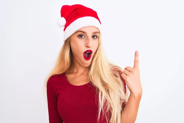 年轻美丽的女人戴着圣诞圣诞礼帽 站在孤独的白色背景上 指指点点着成功的点子 又兴奋又快乐 第一部分 — 图库照片