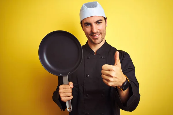 Jonge Chef Kok Uniform Hoed Met Kookpan Geïsoleerde Gele Achtergrond — Stockfoto