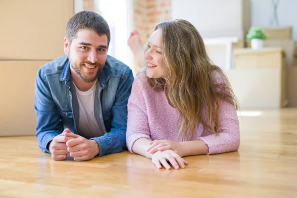 Joven hermosa pareja en el amor relajante tumbado en el suelo para conseguir — Foto de Stock