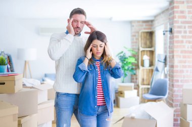 Genç ve güzel bir çift, yeni evlerinde karton kutuların etrafında duruyorlar. Elleri başının üstünde, stres yüzünden başları ağrıyor. Migren ağrısı..