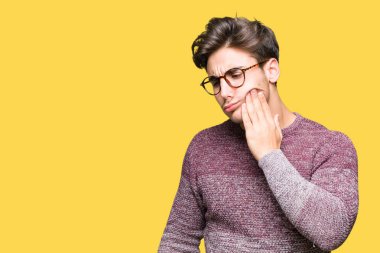 Diş ağrısı veya dişlerde dişlerle ilgili hastalık nedeniyle ağız acı ifadesi ile el ile dokunmak izole arka plan üzerinde gözlük takan yakışıklı delikanlı. Diş hekimi kavramı.