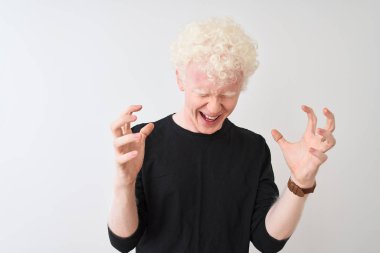 Siyah tişörtlü genç albino sarışın adam izole edilmiş beyaz arka planda duruyor ve başarı için çıldırıyor kollarını kaldırmış, gözlerini kapatmış heyecanlı çığlıklar atıyordu. Kazanan konsept