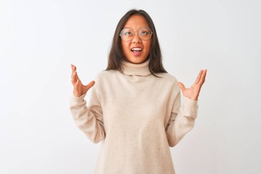 Balıkçı yaka kazak ve gözlük takan genç Çinli kadın izole edilmiş beyaz arka planda çılgınca bağırıyor ve agresif bir ifade ve kollarla bağırıyor. Hayal kırıklığı konsepti.