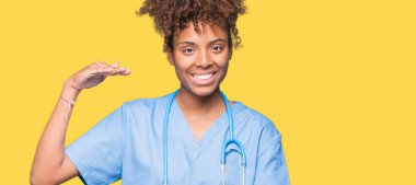 Eller genç Afro-Amerikan doktor kadın izole arka plan ile el hareketi üzerinde büyük ve büyük boy işaret, ölçü birimi sembol gösteren. Kameraya bakarak gülümsüyordu. Ölçüm kavramı.