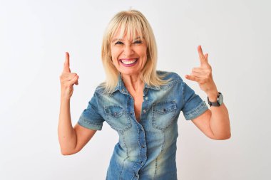 Orta yaşlı kadın, izole edilmiş beyaz arka plan üzerinde dikilmiş, elleri havada rock sembolü yapan çılgın bir ifadeyle bağırıyor. Müzik yıldızı. Ağır konsept.