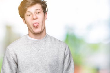 Dilini izole arka plan üzerinde sweatshirt giyen genç yakışıklı sportif adam out komik ifade ile mutlu. Duygu kavramı.