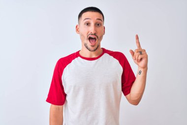 Tecrit edilmiş arka planda duran yakışıklı genç adam başarılı bir fikir işaret ediyor. Heyecanlı ve mutlu. Bir numara..
