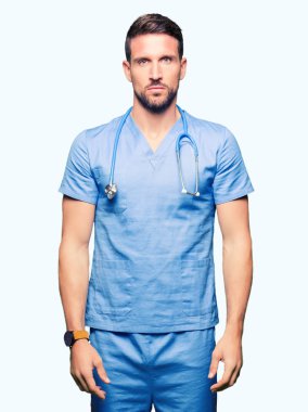 Yakışıklı Doktor adam üzerinde tıbbi üniforma arka plan gevşek yüzünde ciddi bir ifade ile izole. Basit ve doğal kameraya bakıyor.