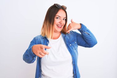 İzole edilmiş beyaz arka plan üzerinde duran güzel bir kadın gülümsüyor telefonda konuşuyor ve seni işaret ediyor. Ara beni..