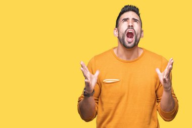 Genç yakışıklı adam izole arka plan çılgın ve kızgın bağırarak ve agresif ifade ve silah kaldırdı bağırıyor. Hayal kırıklığı kavramı.