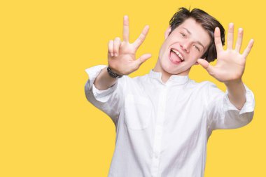 Genç yakışıklı iş adamı gösterilen ve parmakları ile işaret izole arka plan üzerinde kendinden emin ve mutlu gülümseyerek süre sekiz numara.
