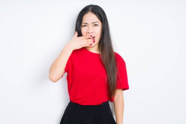 Güzel esmer kadın izole edilmiş arka planda kırmızı tişört giyiyor. Elle ağzını kapatmaktan sıkılmış. Huzursuz ve uykulu..