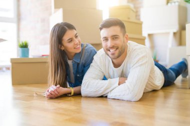 Yeni evin katında yatan genç güzel çift, yeni daireye taşınmak için çok mutlu aşk gülümsüyor