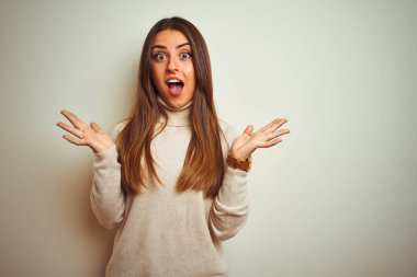 Kışlık balıkçı yaka kazak giyen genç ve güzel bir kadın çılgın ve başarıyı kollarını kaldırıp heyecanla haykırarak kutluyor. Kazanan konsept