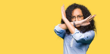 Kıvırcık saçlı genç güzel iş kızı gözlük takıyor Reddedilme ifadesi geçen kollar olumsuz işaret yapıyor, kızgın yüz