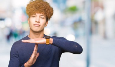 Yakışıklı delikanlı afro saçlı yapıyor zaman aşımı jest elle, sinirli ve ciddi bir yüz