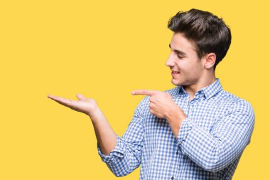 Genç yakışıklı iş adamı üzerinden hayran ve el ile sunulması ve parmak ile işaret ederken kameraya gülümseyen izole arka plan.