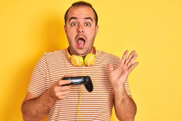 Young Gamer Man Playing Video Game Using Headphones Isolated Yellow — Stock Photo, Image