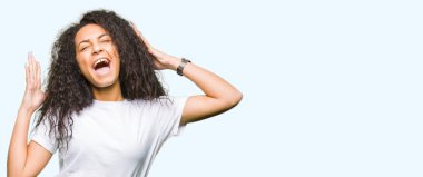 Kıvırcık saçlı deli ve silah ile başarı için deli kutluyor casual beyaz t-shirt giyen genç güzel kız kaldırdı ve heyecanlı çığlık gözler kapalı. Kazanan kavramı