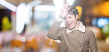 Yakışıklı delikanlı sürpriz giyen kış ceket izole arka plan üzerinde hata için kafasına el ile hata hatırlıyorum. Unuttum, kötü bellek kavramı.