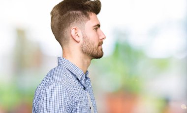 Tarafına, seyir sıradan gömlek giymiş genç yakışıklı sarışın adam sakin ol kendine güvenen gülümseme ile doğal yüz pozuyla profili.