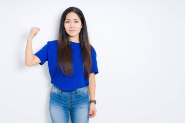 Güzel esmer kadın, izole edilmiş arka planda güçlü kol kası gösteren, kendinden emin ve gururlu biri.